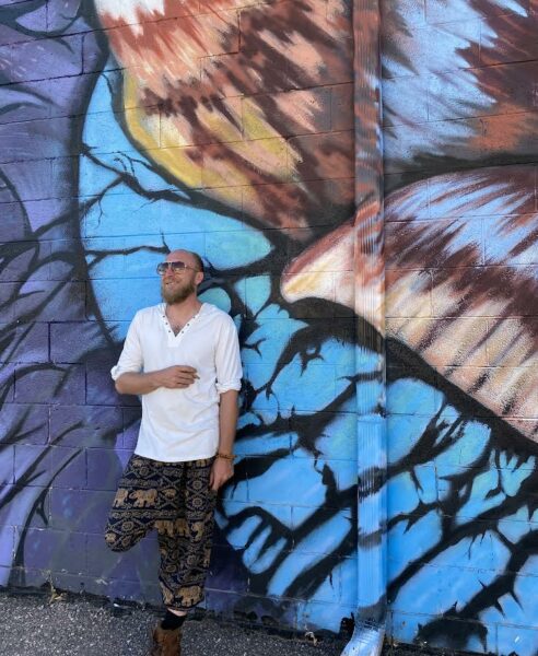 man standing in front of colorful mural